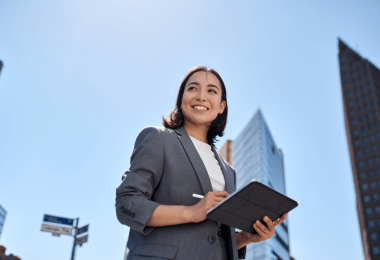 Smiling businesswoman holding a tablet outdoors