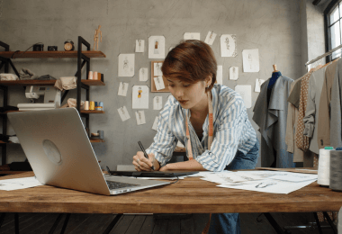Designer working at a laptop in a fashion studio