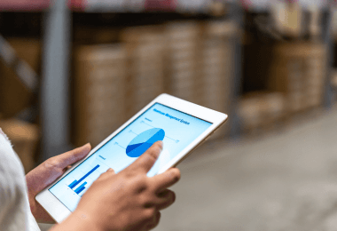 Hands holding a tablet showing an inventory chart