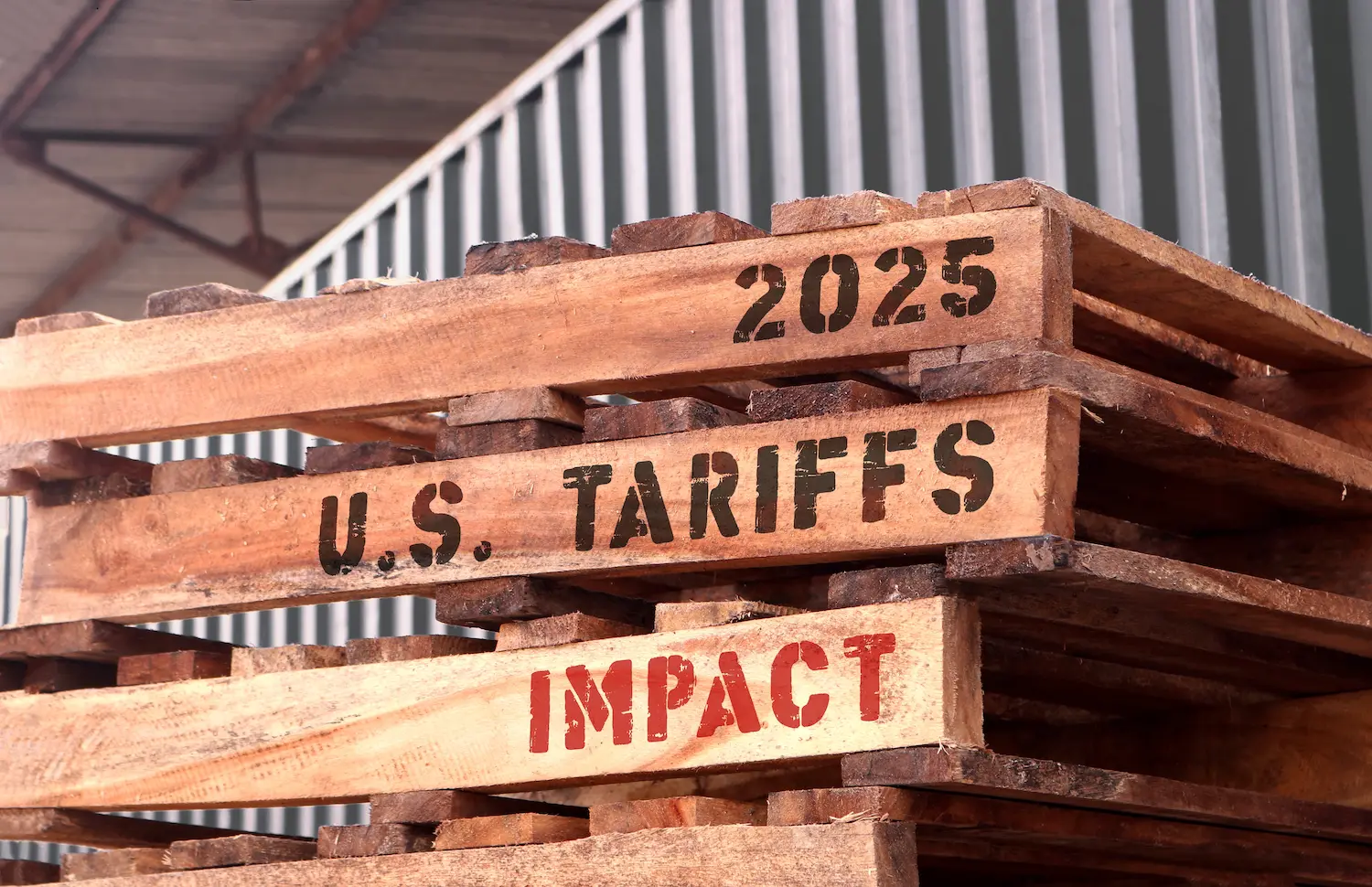 2025 U.S. Tariffs Impact, text written on piled-up pallets