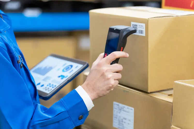 Warehouse worker scanning a package barcode with a handheld scanner