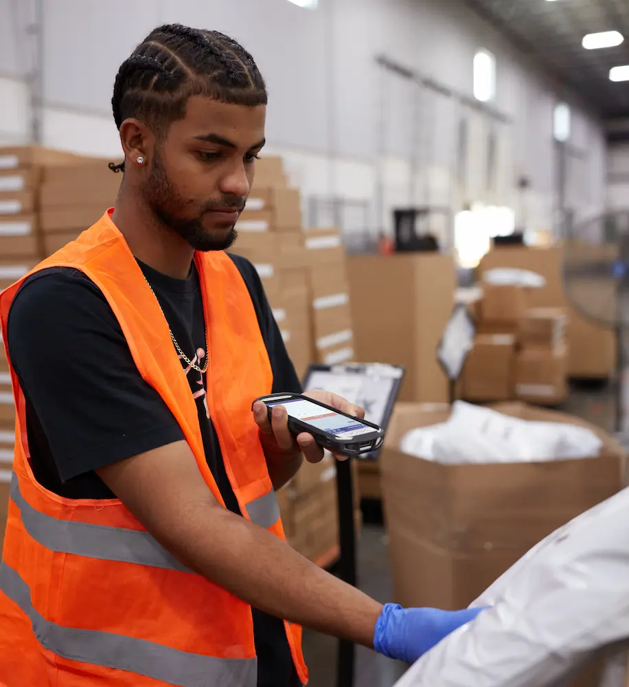Boxzooka warehouse employee scanning a package with a handheld device, showcasing tech-driven accuracy in order fulfillment operations.