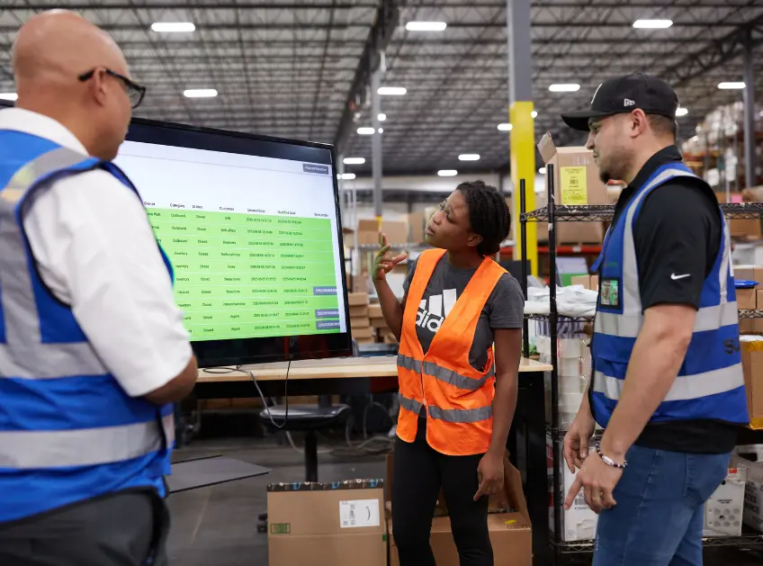 Boxzooka team reviewing inventory data on a warehouse monitor