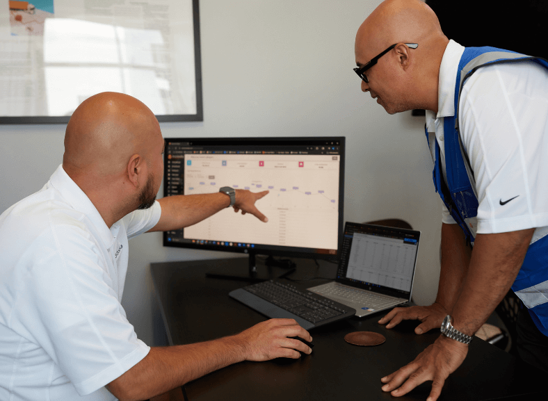 Two Boxzooka employees reviewing data on a computer monitor