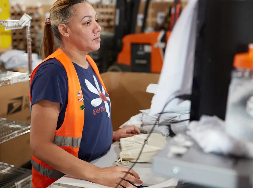 Warehouse associate working at a packing station computer