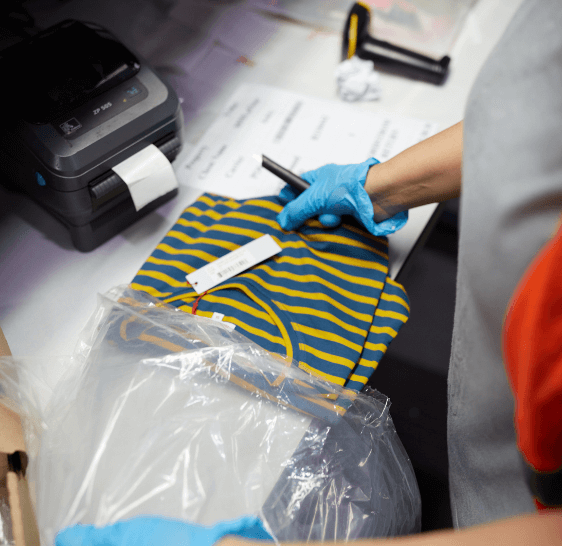 Warehouse associate scanning and bagging a folded garment