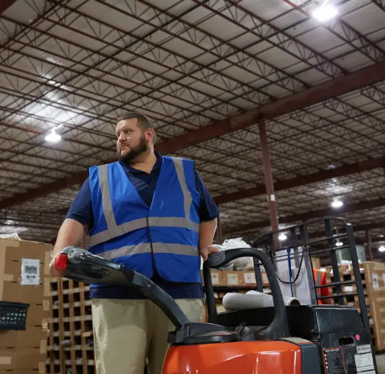 Warehouse associate operating a pallet jack