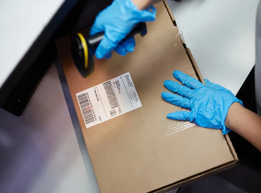 Warehouse associate scanning a shipping label on a package