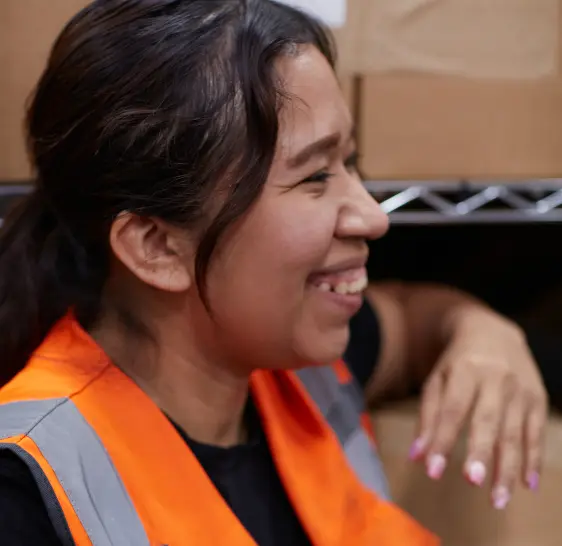 Smiling warehouse associate in a safety vest