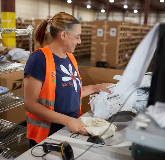 Warehouse associate packing an order at a workstation