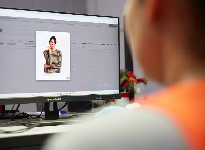 Warehouse associate reviewing a product listing on a computer monitor
