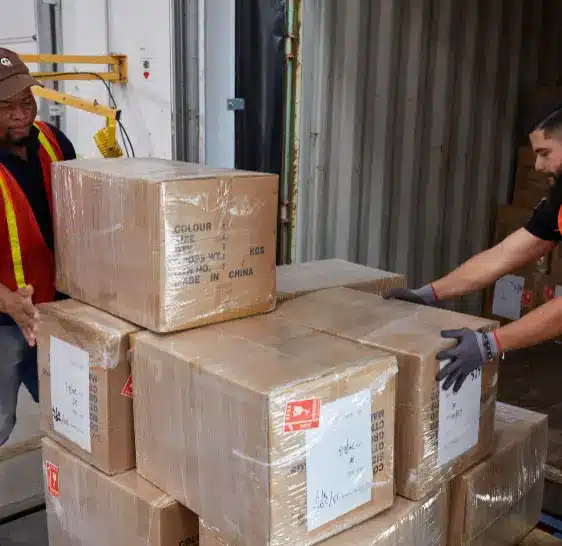Warehouse associates unloading boxes from a shipping container