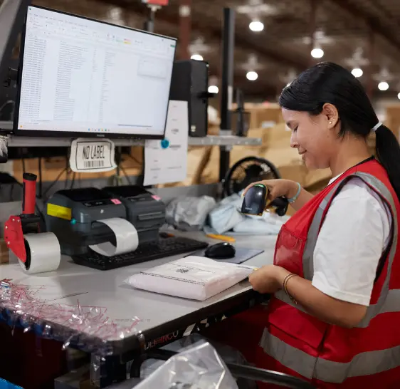 Warehouse associate printing shipping labels at a workstation