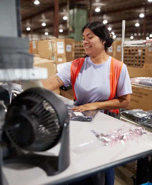 Warehouse associate smiling while packing an order