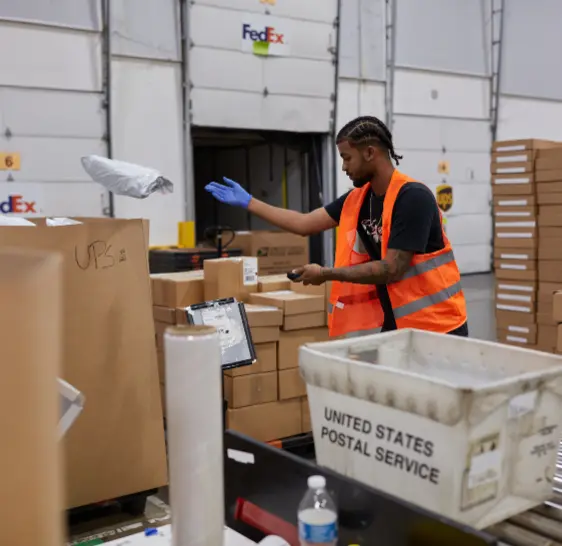 Warehouse associate sorting packages near a shipping dock