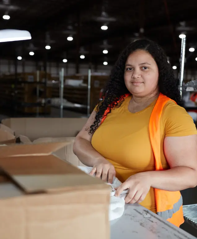 Portrait of a warehouse associate packing an order