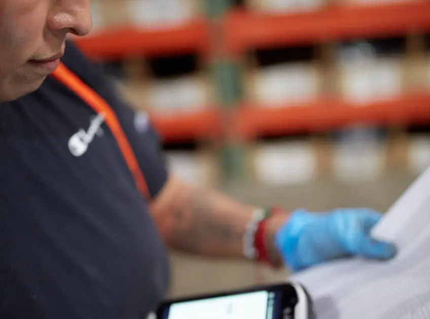 Close up of a warehouse associate reviewing a packing slip
