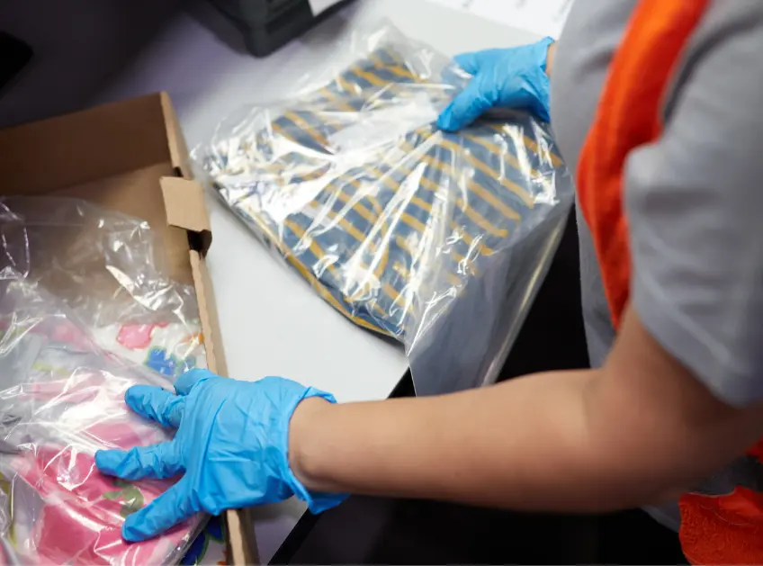 Warehouse associate bagging folded garments for shipping