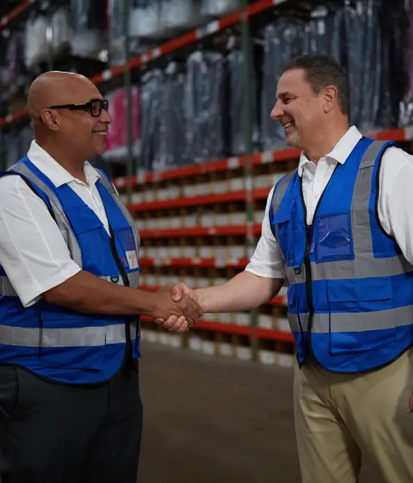 Boxzooka leaders shaking hands in the warehouse, symbolizing strong partnerships, trust, and hands-on client success in fulfillment.