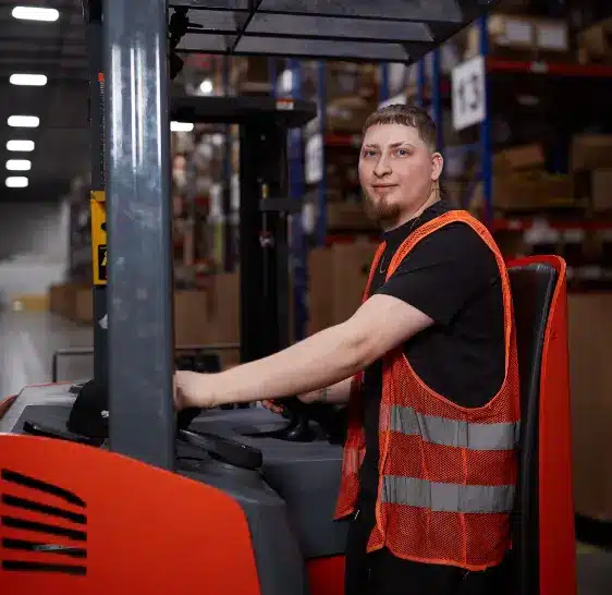 Warehouse associate operating a reach truck in a storage aisle