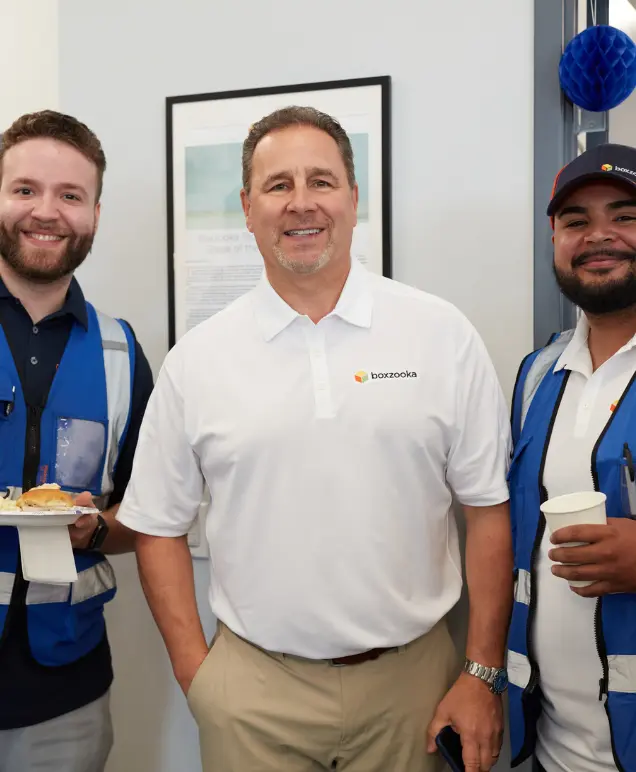 Three Boxzooka team members smiling together at an office event