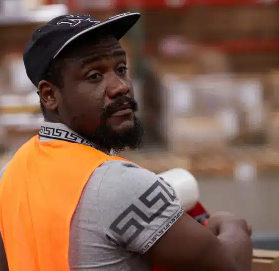 Warehouse associate looking over his shoulder in a storage aisle