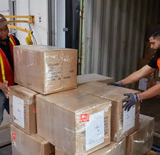 Warehouse associates unloading boxes from a shipping container
