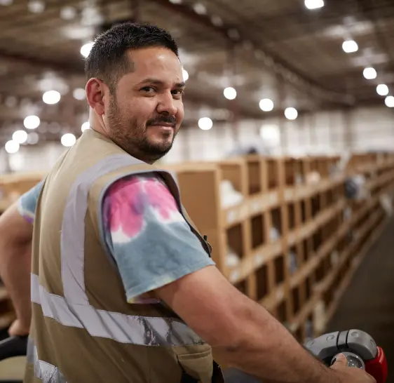 Boxzooka warehouse associate on a pallet jack among storage racks