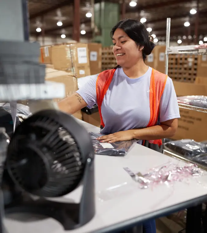 Boxzooka warehouse employee smiling while working, symbolizing the approachable and people-first support clients receive when contacting Boxzooka.