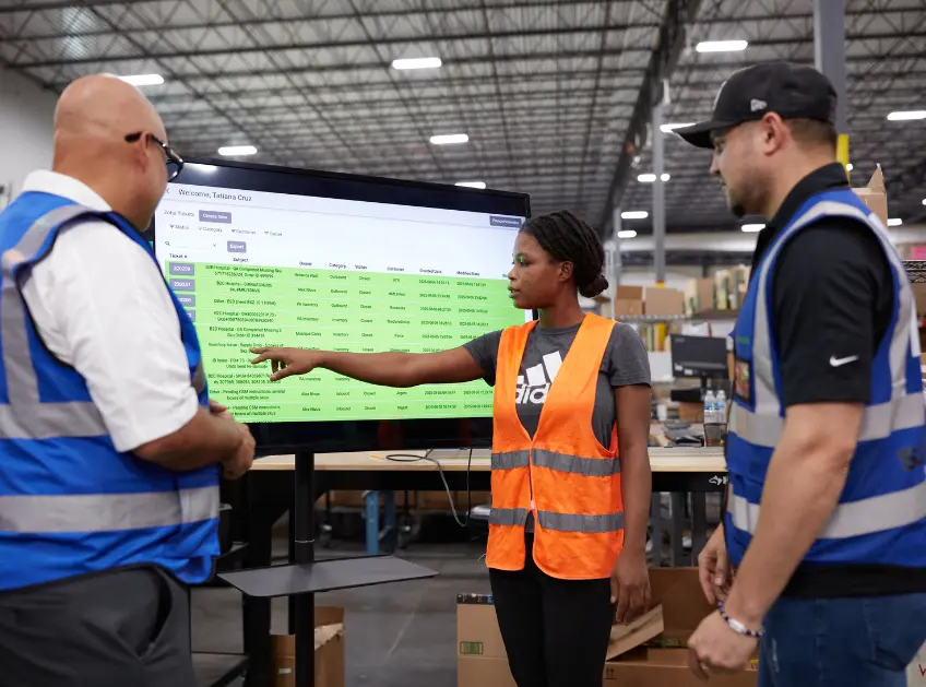 Boxzooka team reviewing inventory data on a warehouse monitor