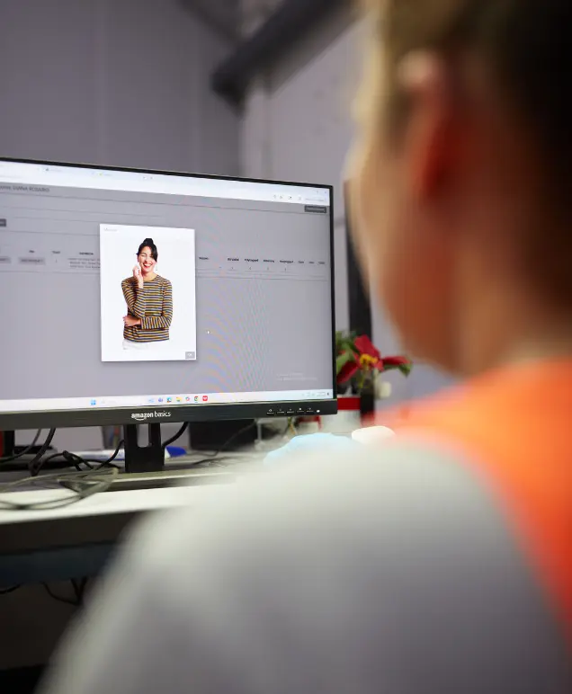 Warehouse associate reviewing a product listing on a computer monitor