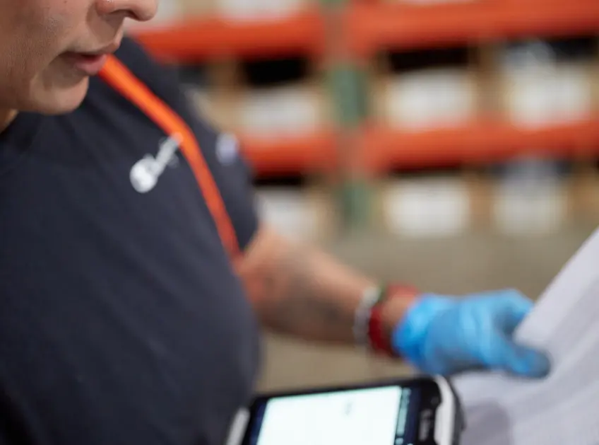 Close up of a warehouse associate reviewing a packing slip