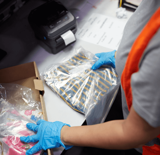 Warehouse associate bagging folded garments for shipping