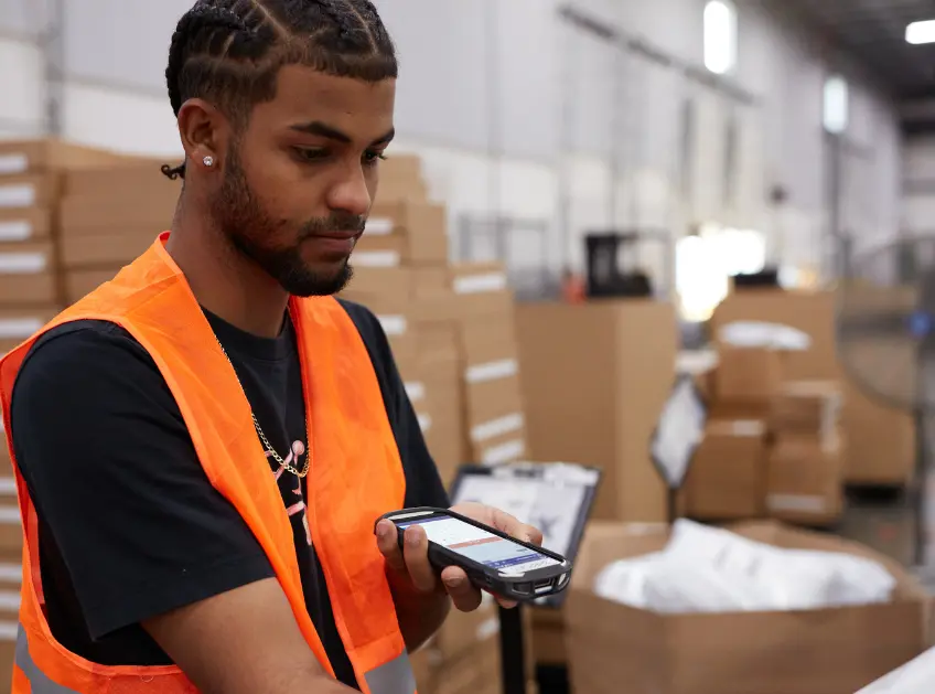 Warehouse associate scanning a package with a handheld device