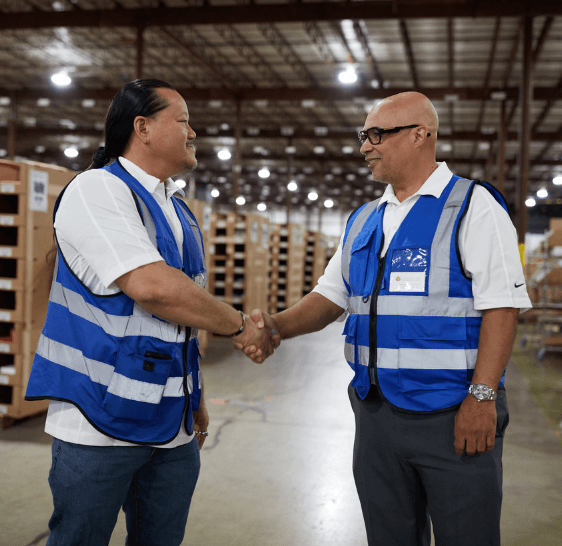 Two Boxzooka team members shaking hands in the warehouse
