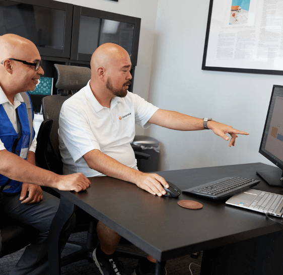 Two Boxzooka employees reviewing data on a computer monitor