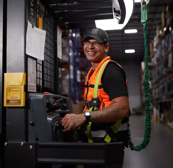 Boxzooka warehouse associate operating an order picker in a storage aisle