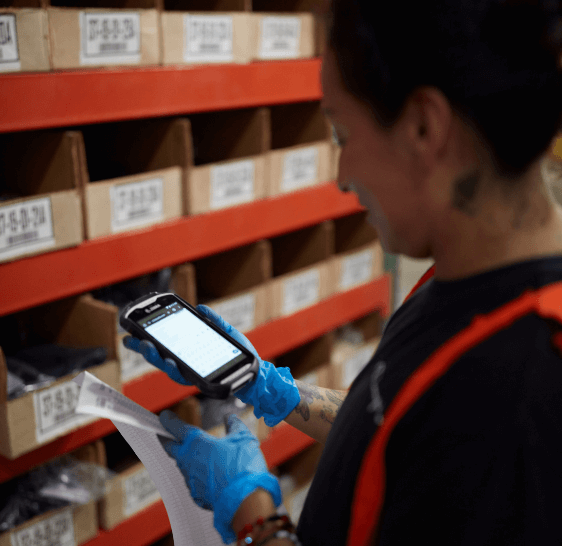 Warehouse associate scanning inventory bins with a handheld scanner