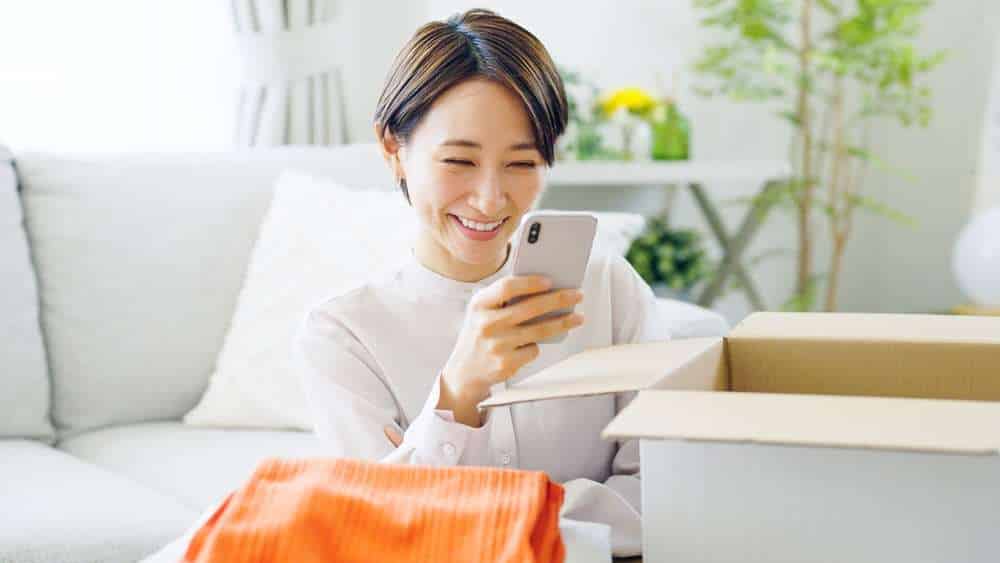 Asian woman putting clothes away in a box