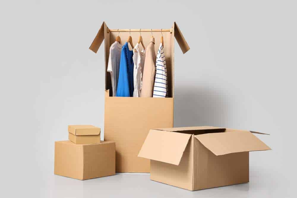 Wardrobe boxes with clothes on grey background