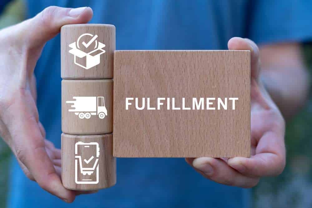 Man holding wooden blocks sees word: FULFILLMENT. Order Fulfillment E-commerce Business Warehouse Distribution concept. Order Fulfillment Management and Delivery Service