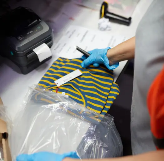 Warehouse associate scanning and bagging a folded garment