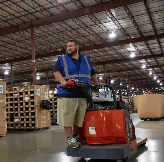 Warehouse associate operating a pallet jack