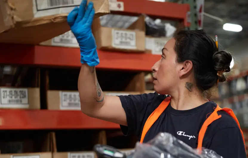 Boxzooka warehouse employee scanning inventory and organizing apparel on shelves, illustrating real-time Squarespace 3PL integration and accurate inventory management.