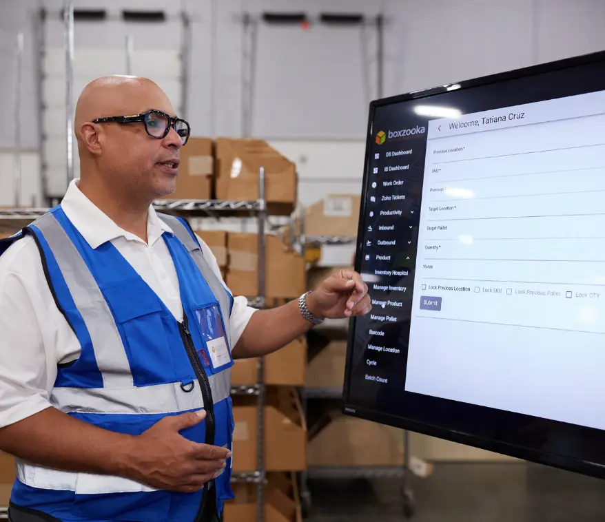 Boxzooka manager demonstrating the company’s proprietary 3PL technology platform on a large screen, showcasing advanced tools for inventory and order management.
