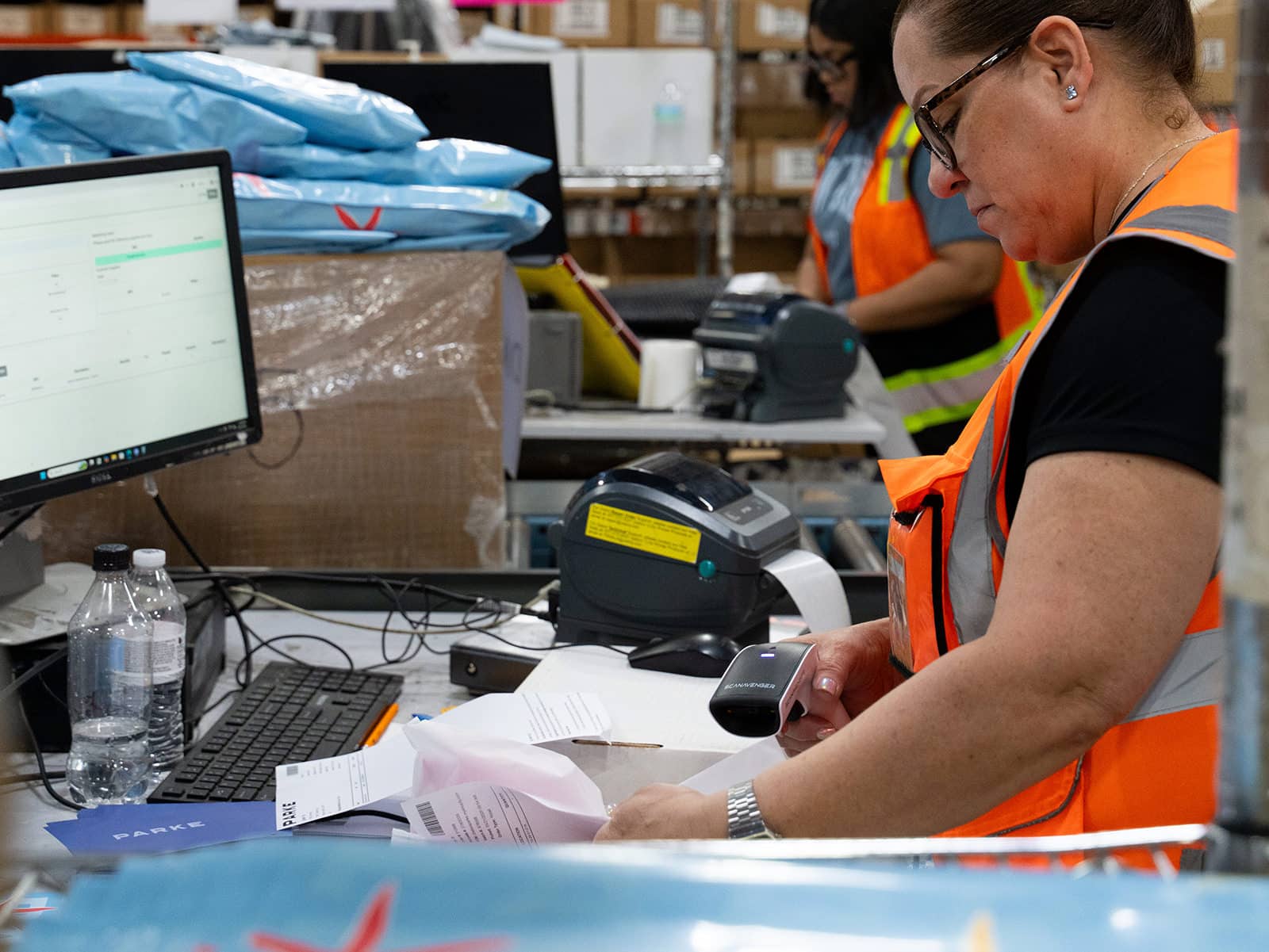 worker scans a package at a 3PL shipping station