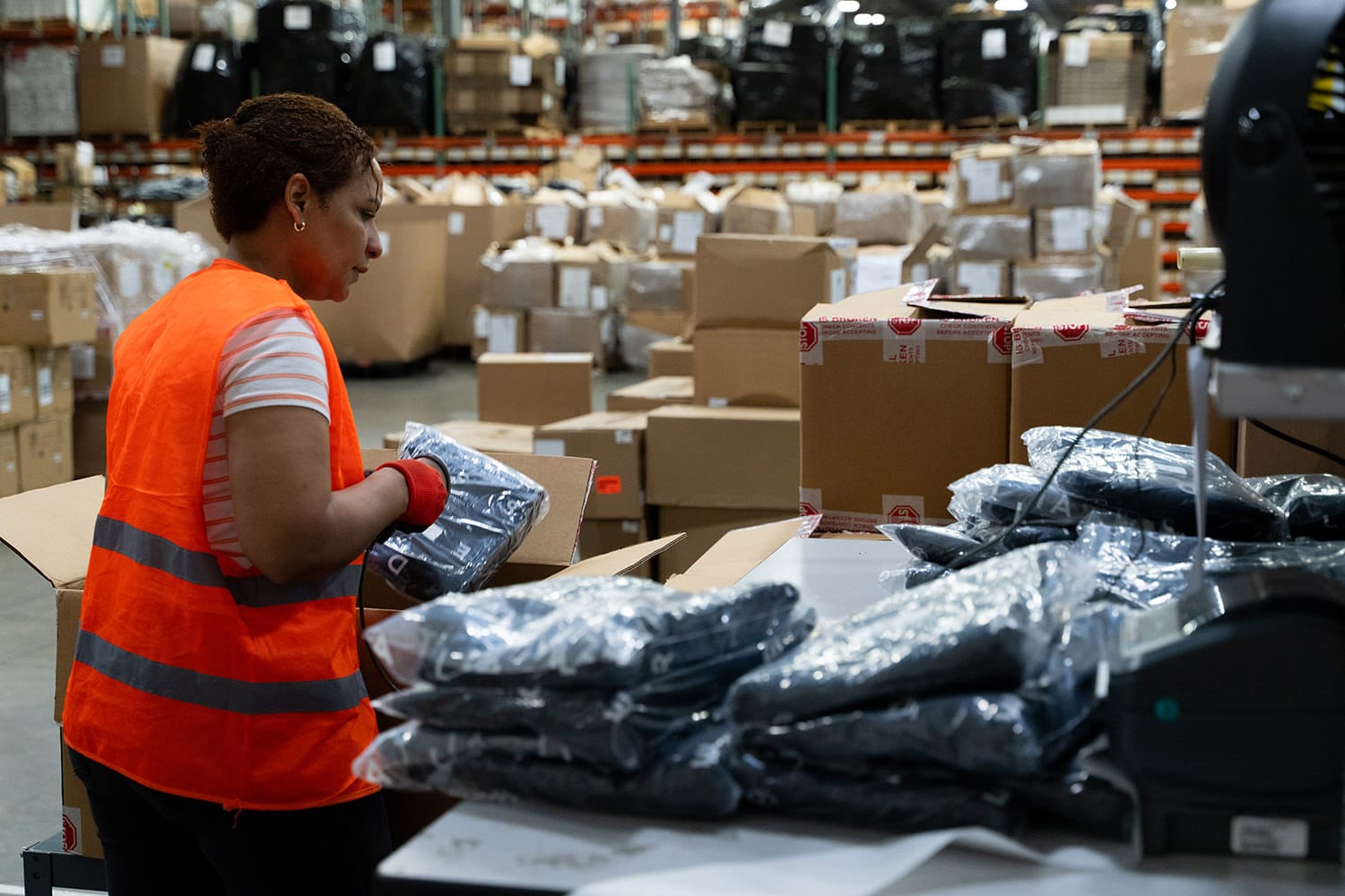 woman scans apparel items at a 3PL shipping station