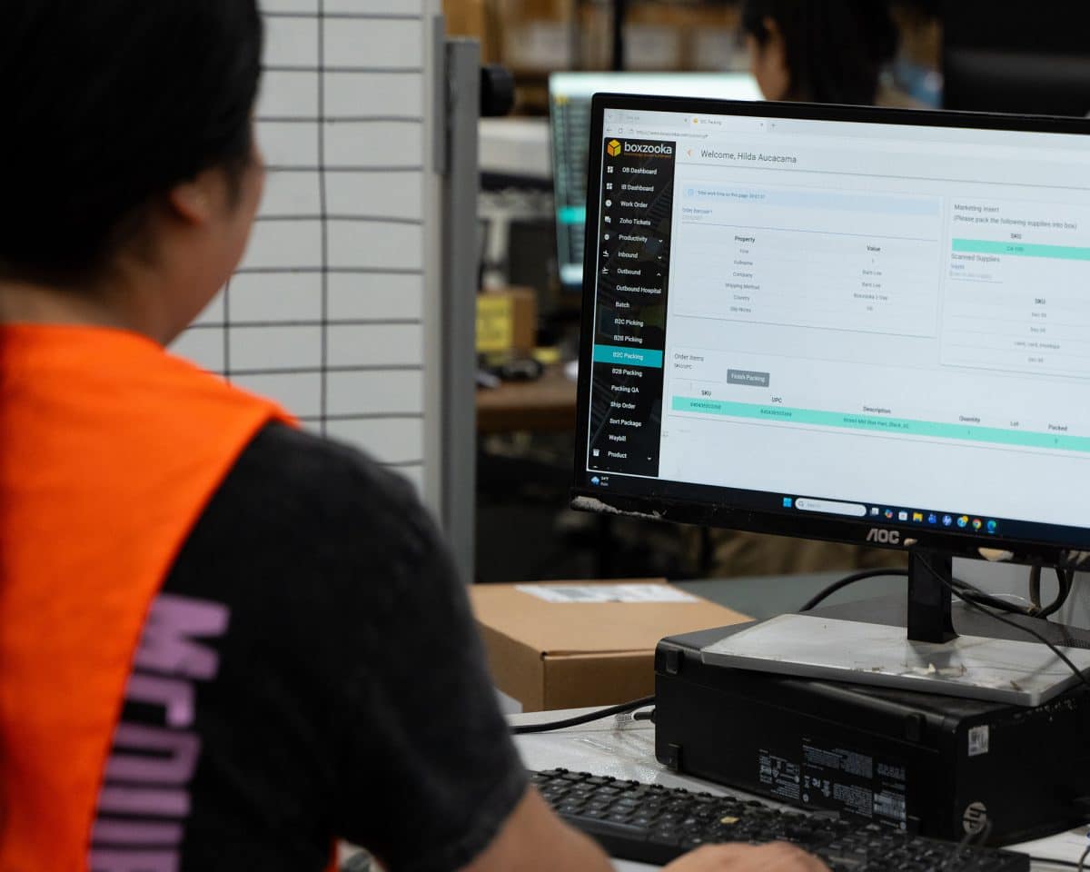 3PL worker at a station using a WMS
